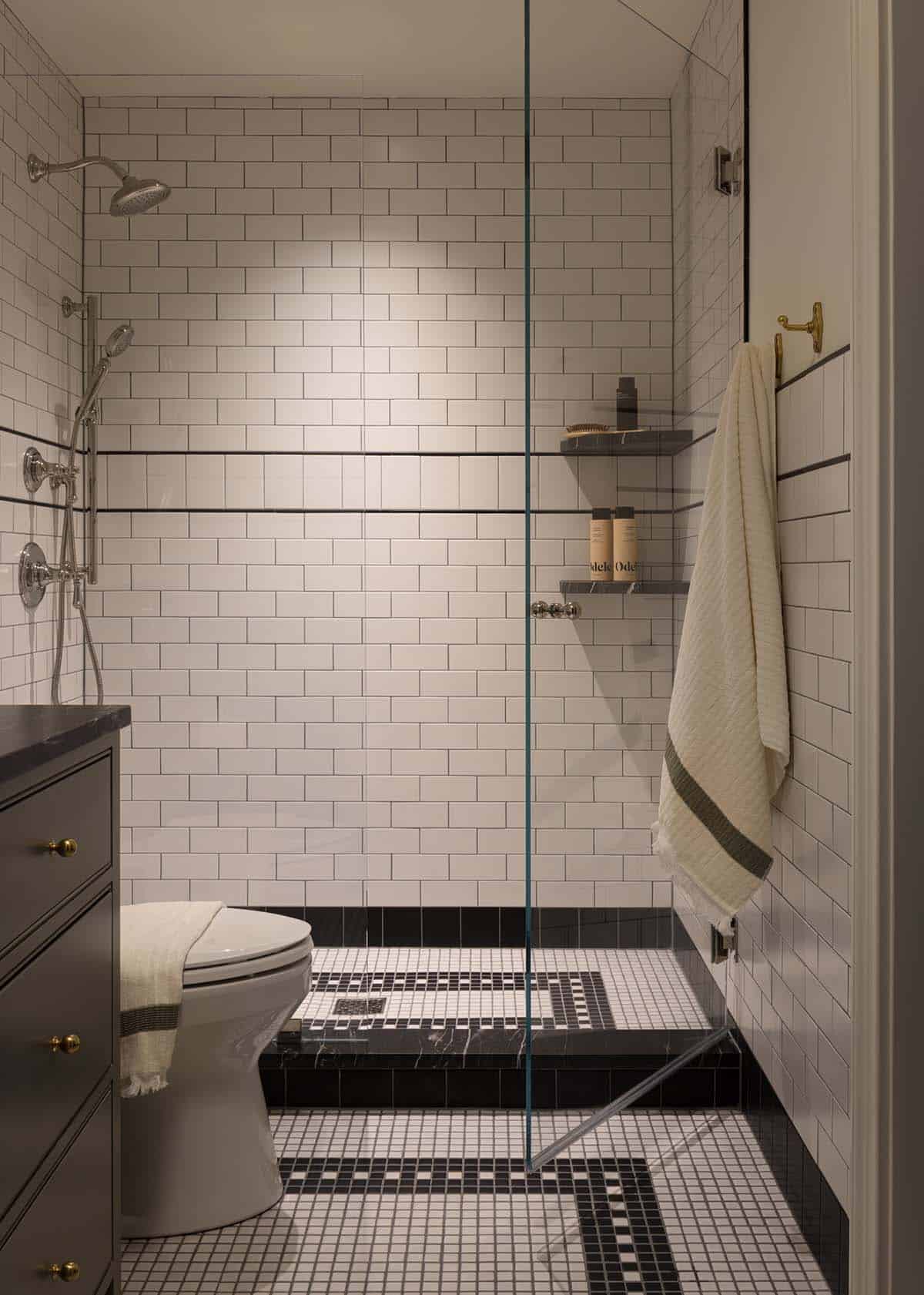 Black and white tiled shower with subway tile walls and mosaic floor