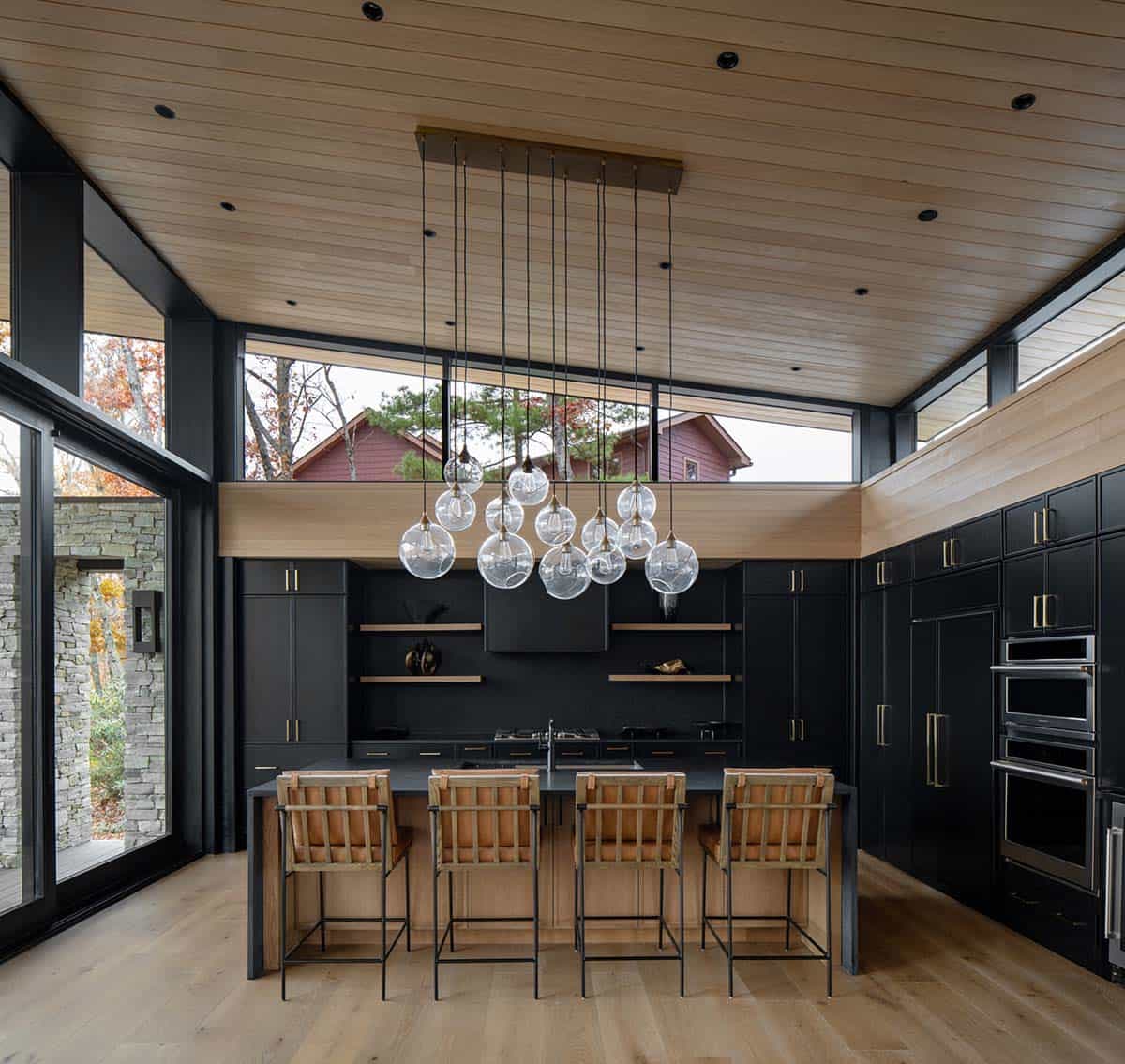 Modern kitchen with black cabinetry, wood ceiling, and cluster of glass globe pendant lights