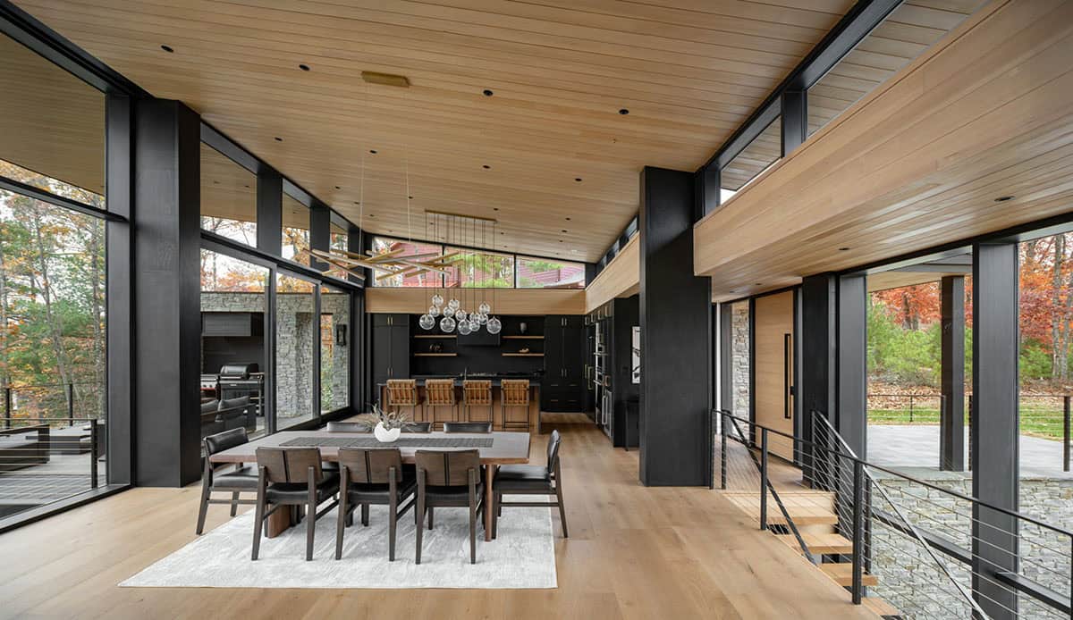 Great room with dining table, kitchen, and wood-paneled vaulted ceiling