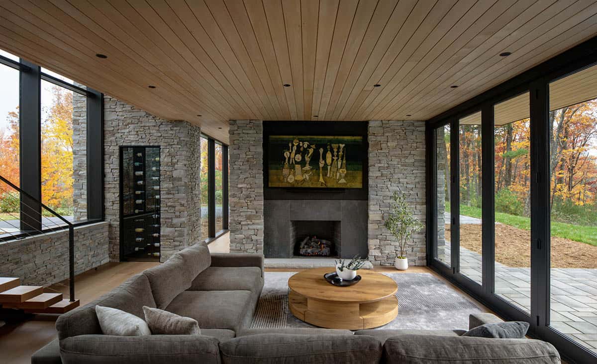 Living room with sectional sofa, stone fireplace, and round wood coffee table