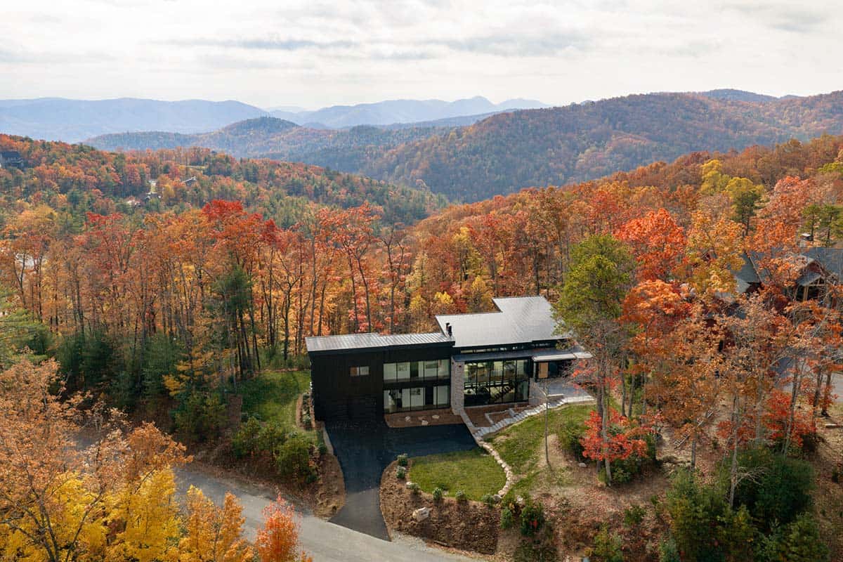 Aerial view of home in autumn forest with Blue Ridge Mountains stretching to the horizon