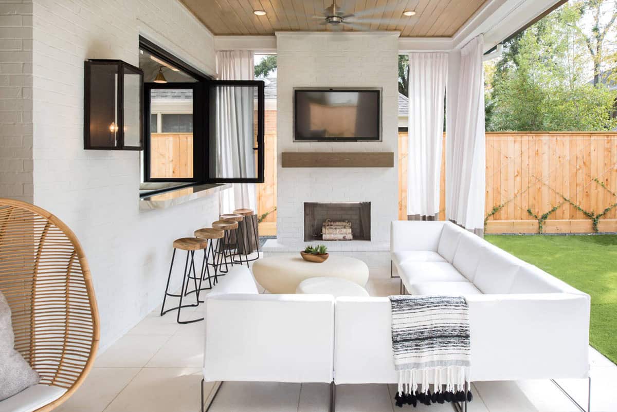 White brick fireplace with mounted TV on a modern covered patio