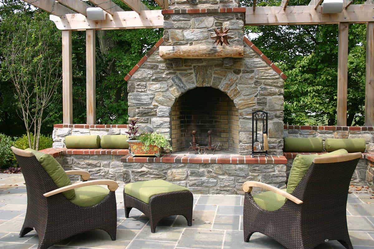 Stone fireplace with arched opening under a wood pergola