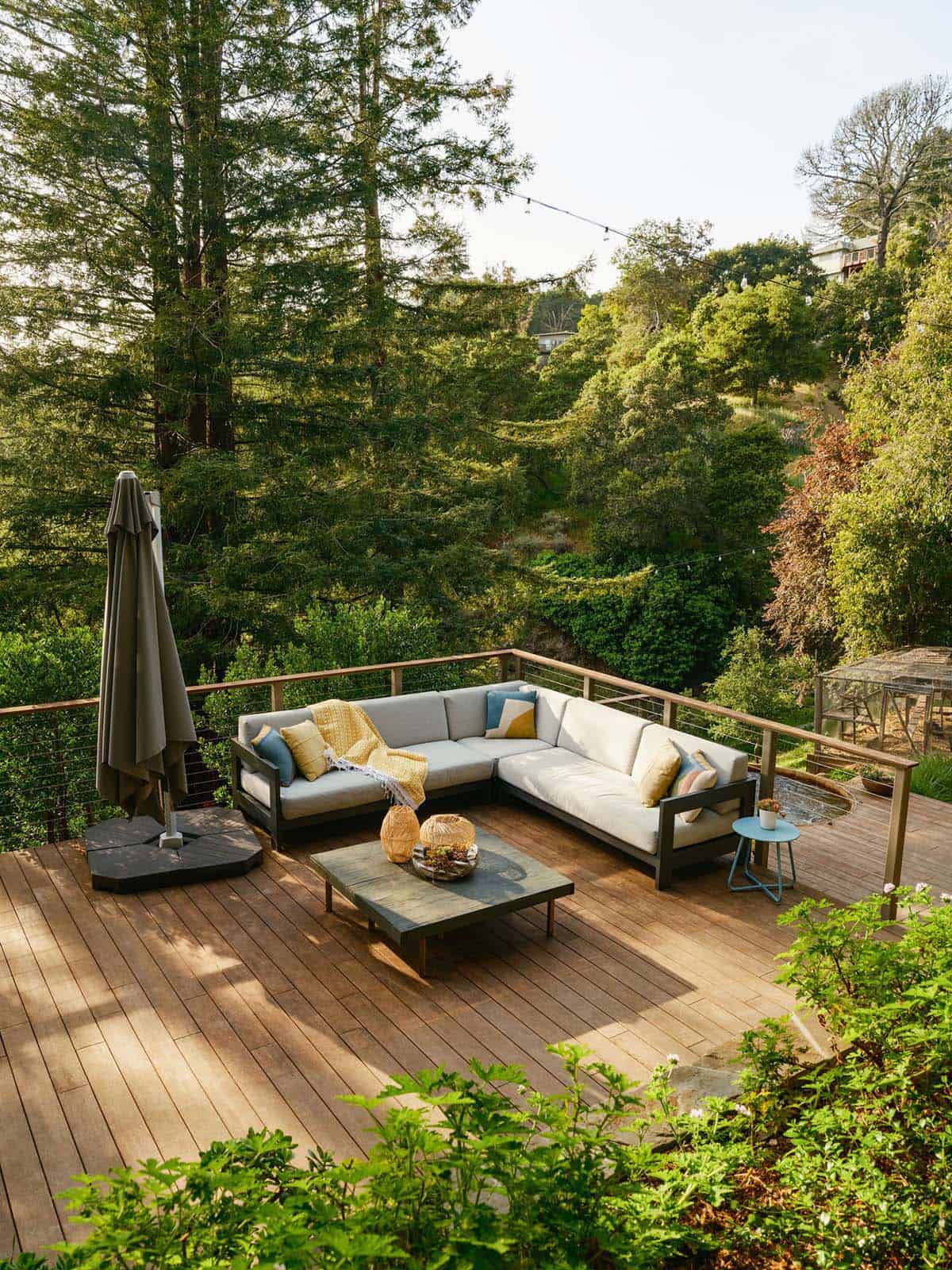 Wood deck L-shaped sectional overlooking wooded hillside at Oakland, California retreat