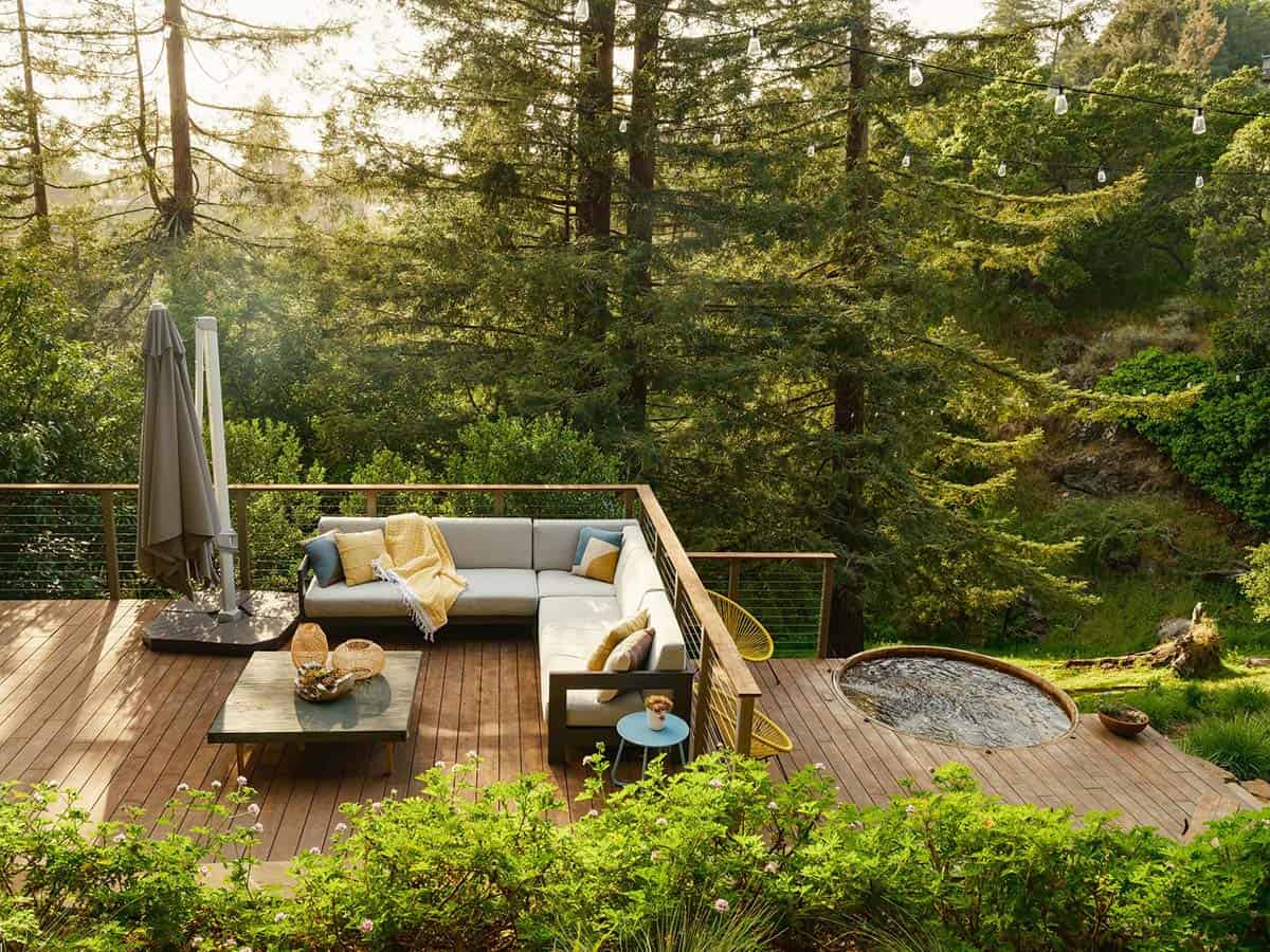 Wood deck at Hilltop Hot Tub Refuge in Oakland, California with L-shaped sectional and soaking tub