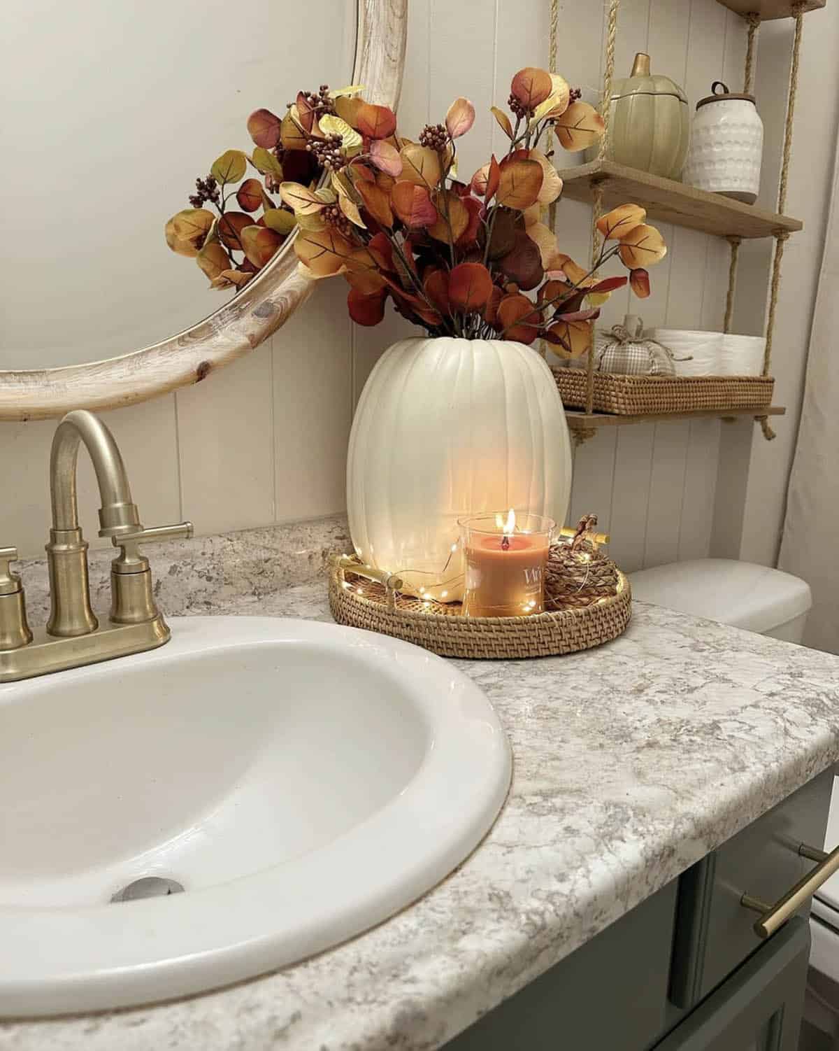 Bathroom vanity tray with string lights, candle and pumpkin vase