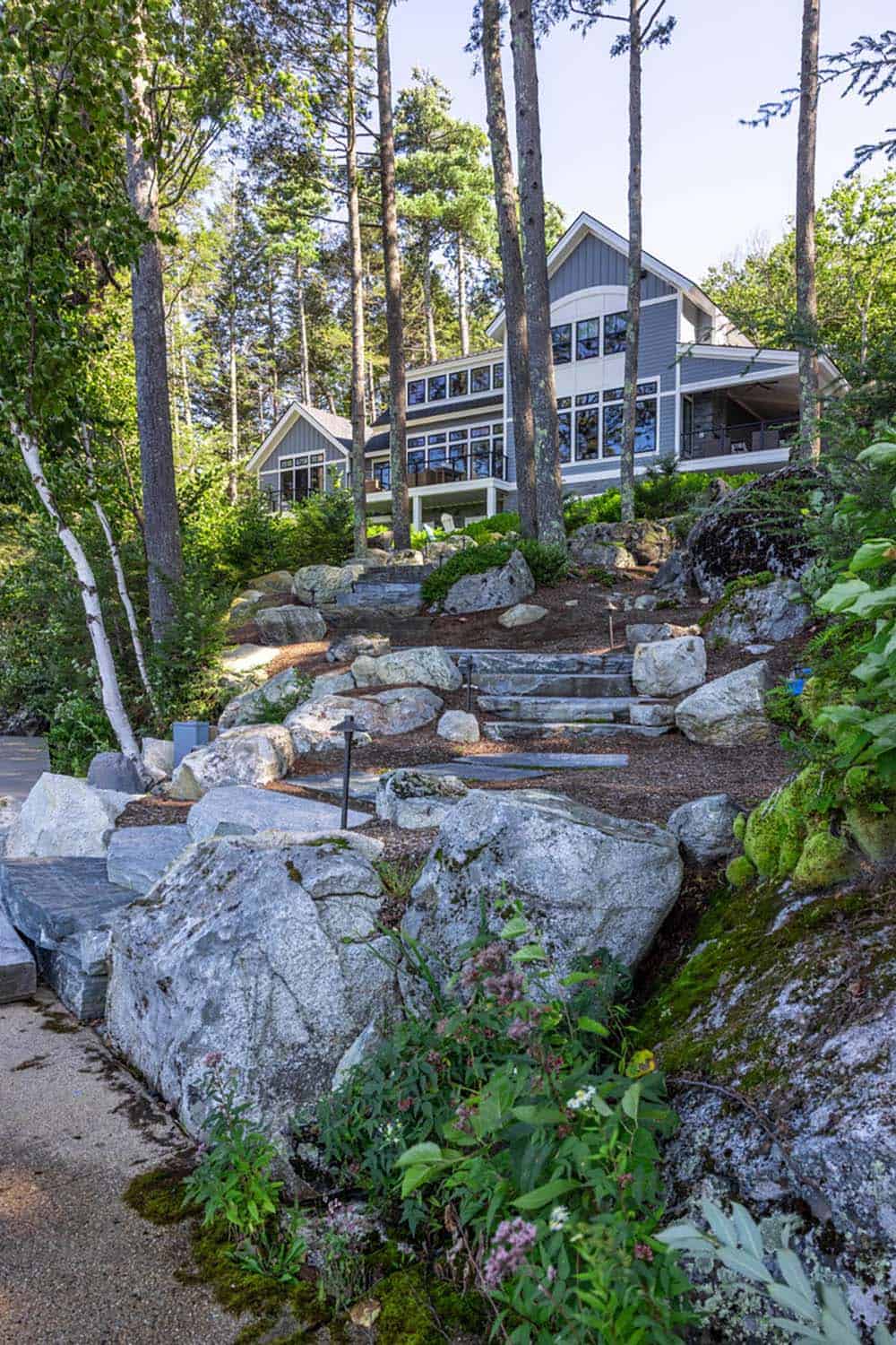 Boulder-lined stone staircase rising from the shore to the cottage