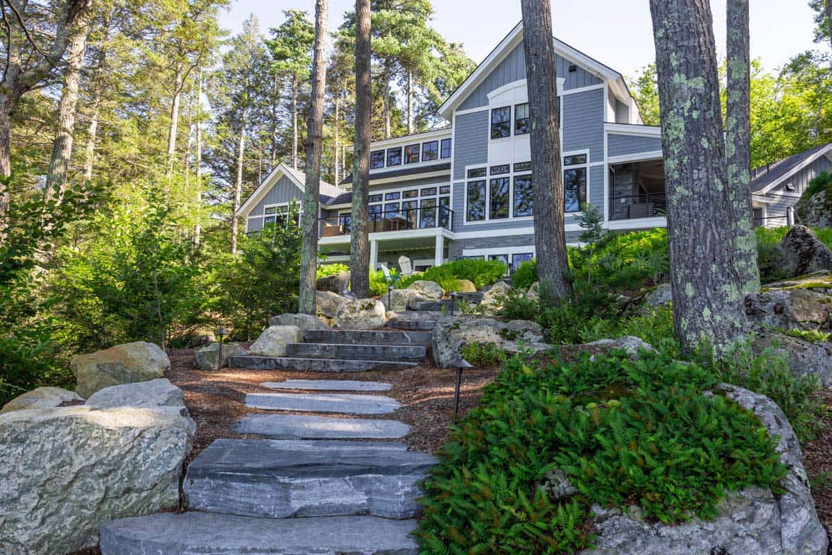 Natural stone steps and path lighting lead through ferns to cottage