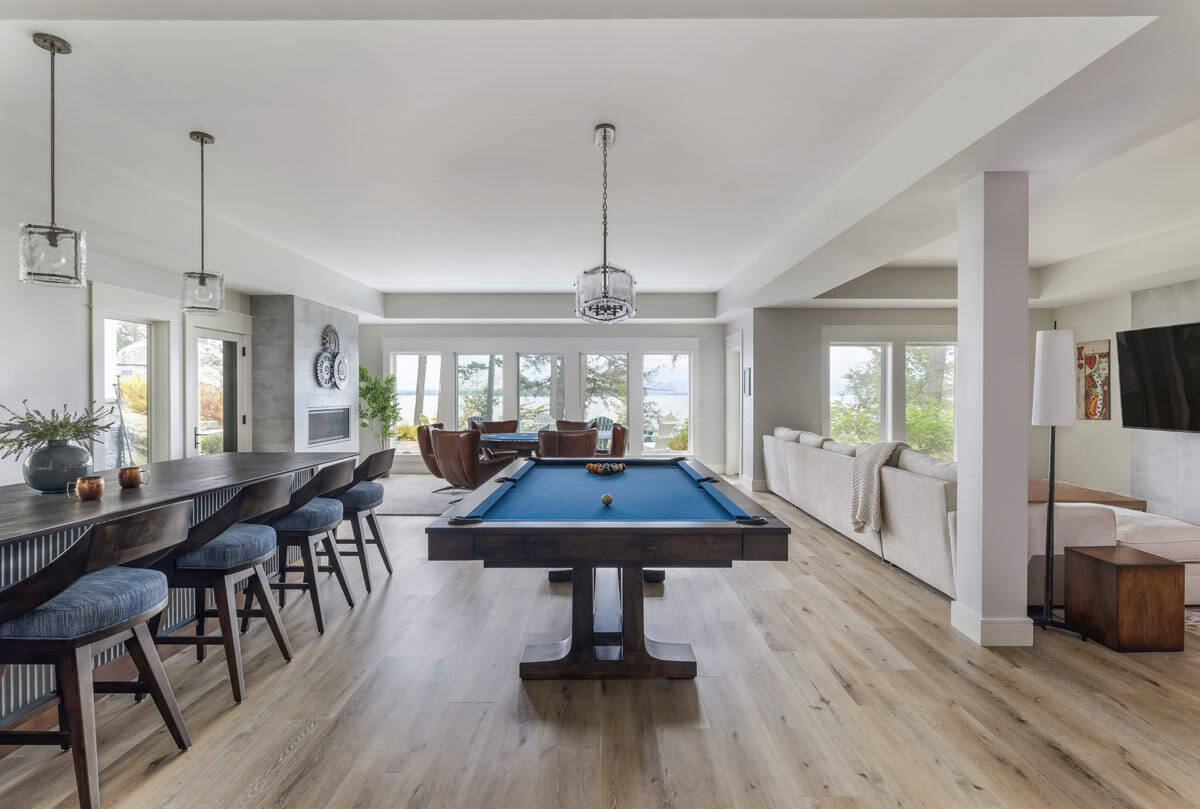 Lower-level game room with pool table, bar seating, and lake views