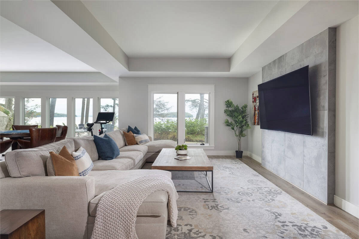 Sectional sofa and tiled media wall in lower-level lounge with lake views