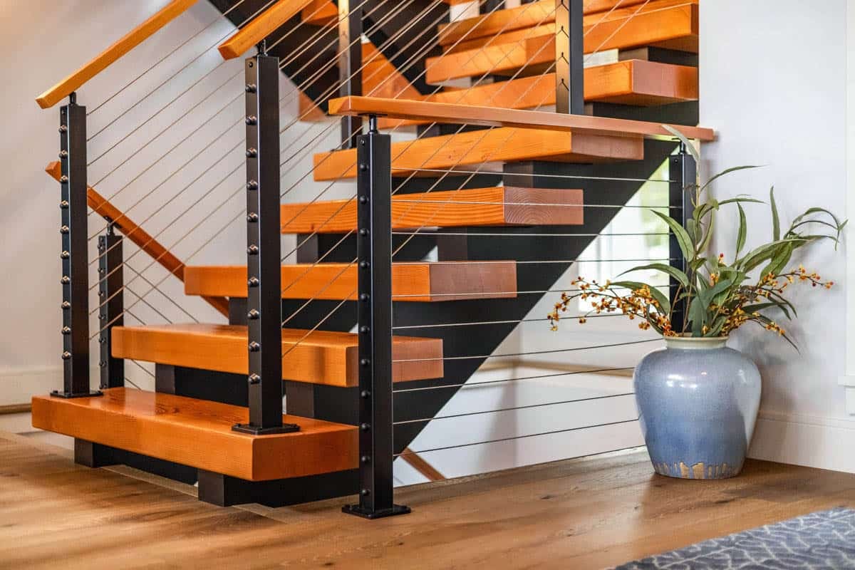 Staircase base with thick wood treads, black posts, and blue vase