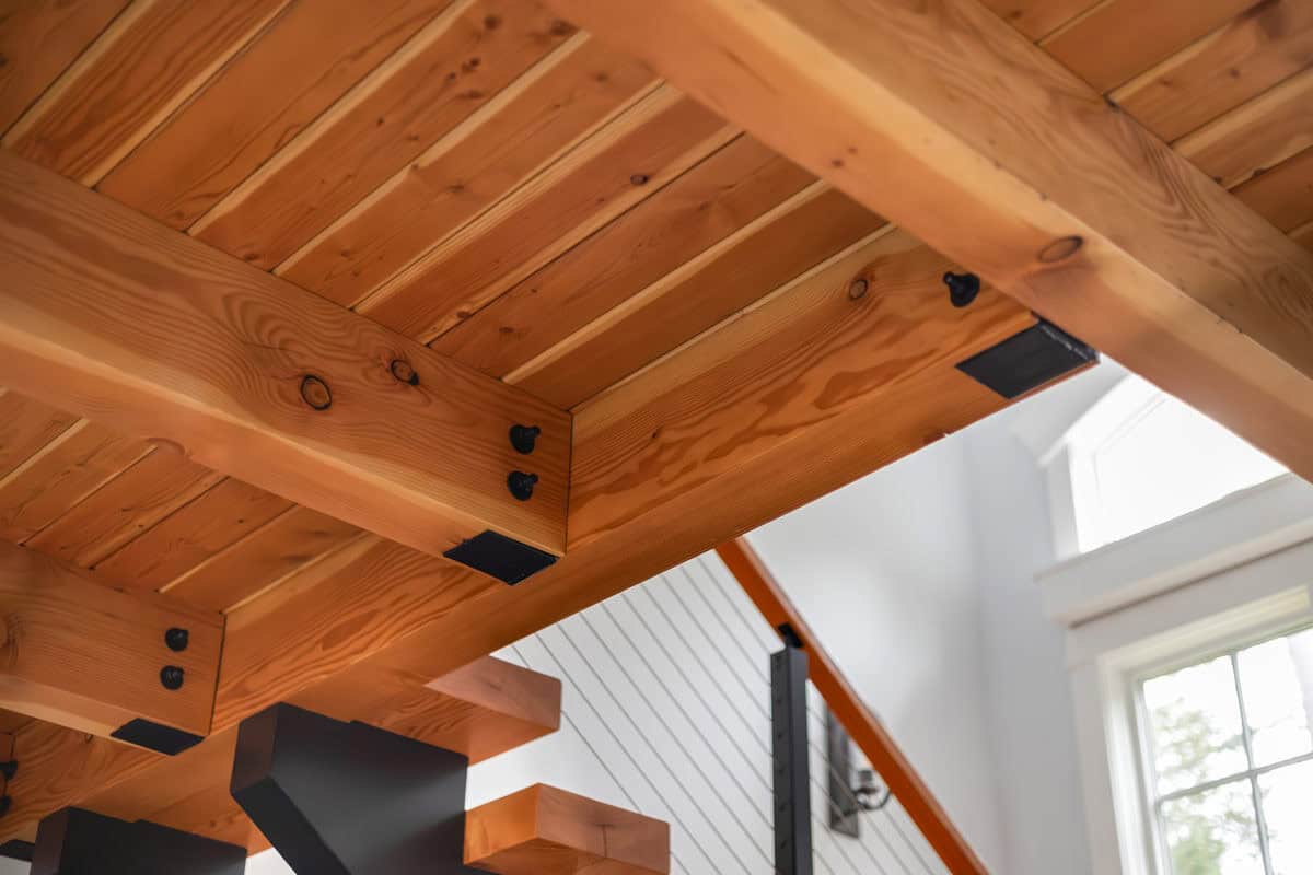 Close-up of bolted timber beams and steel connectors over staircase