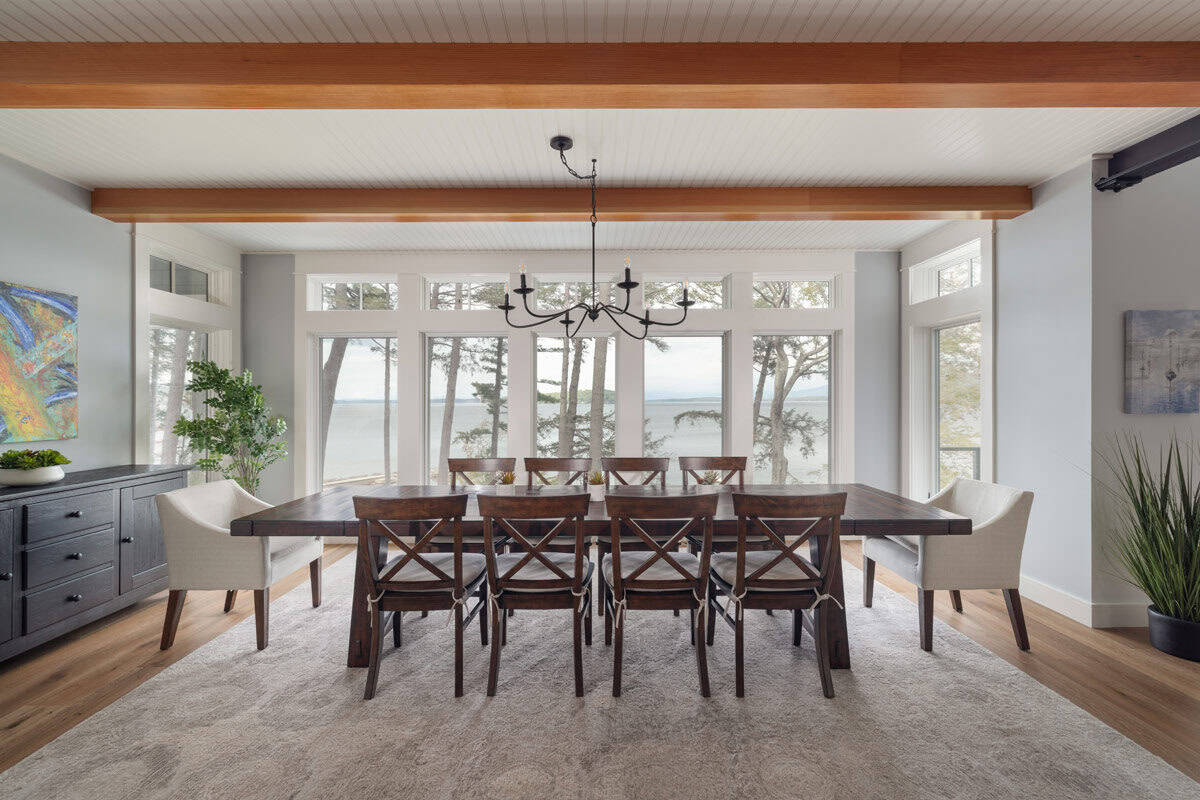Dining room with beamed ceiling, farmhouse table, and lake view windows