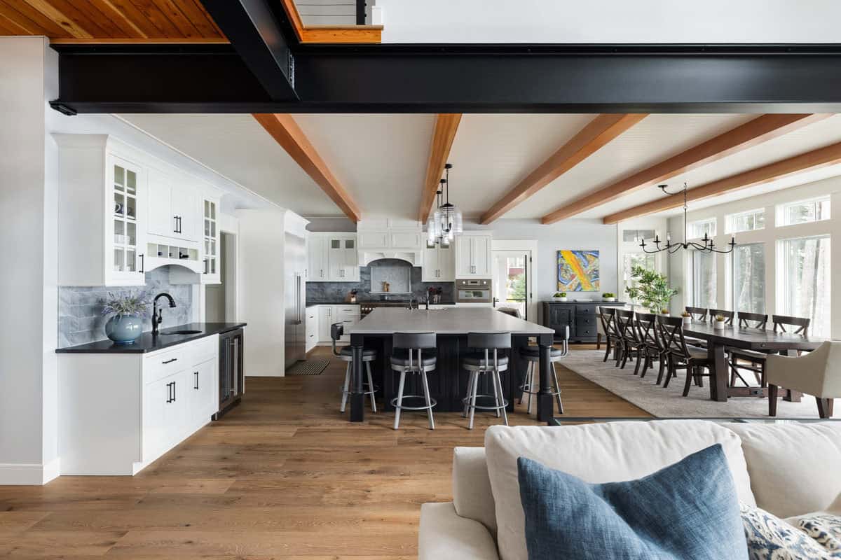 Kitchen and dining space seen past steel beam from living room