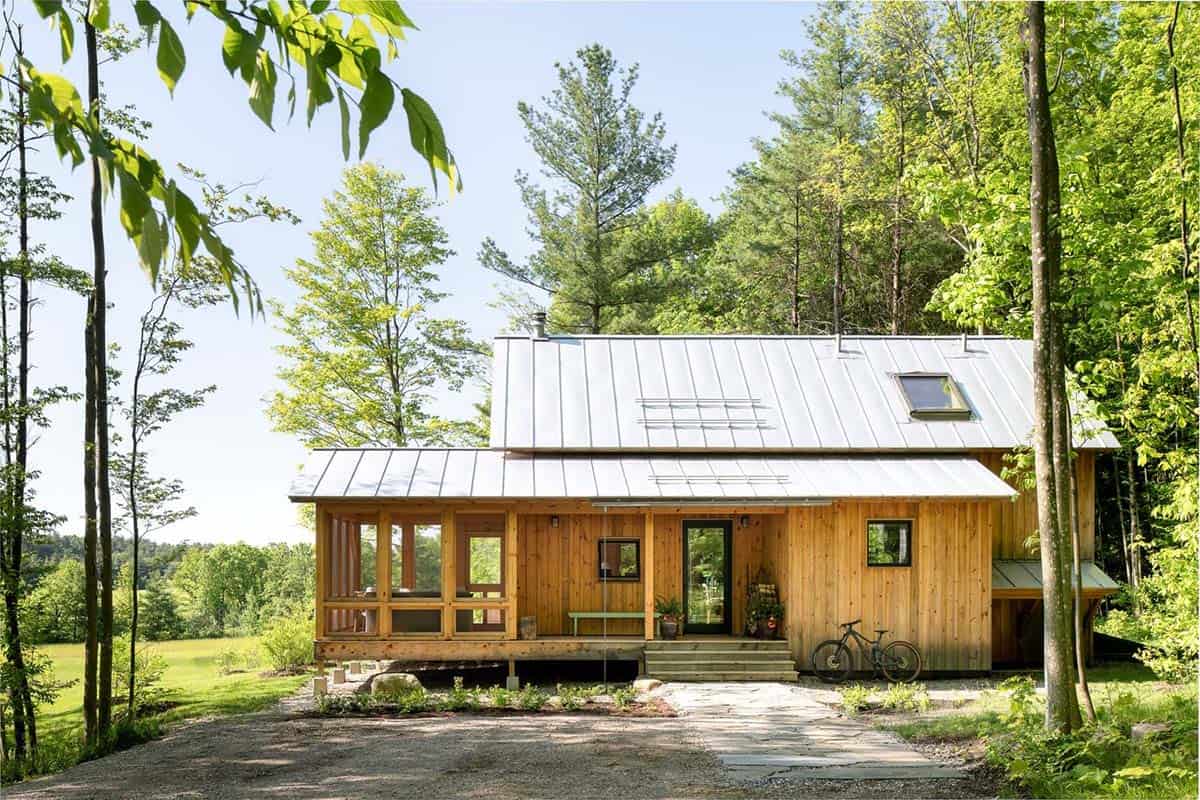 Vermont cabin with metal roof, screened porch, and vertical wood siding