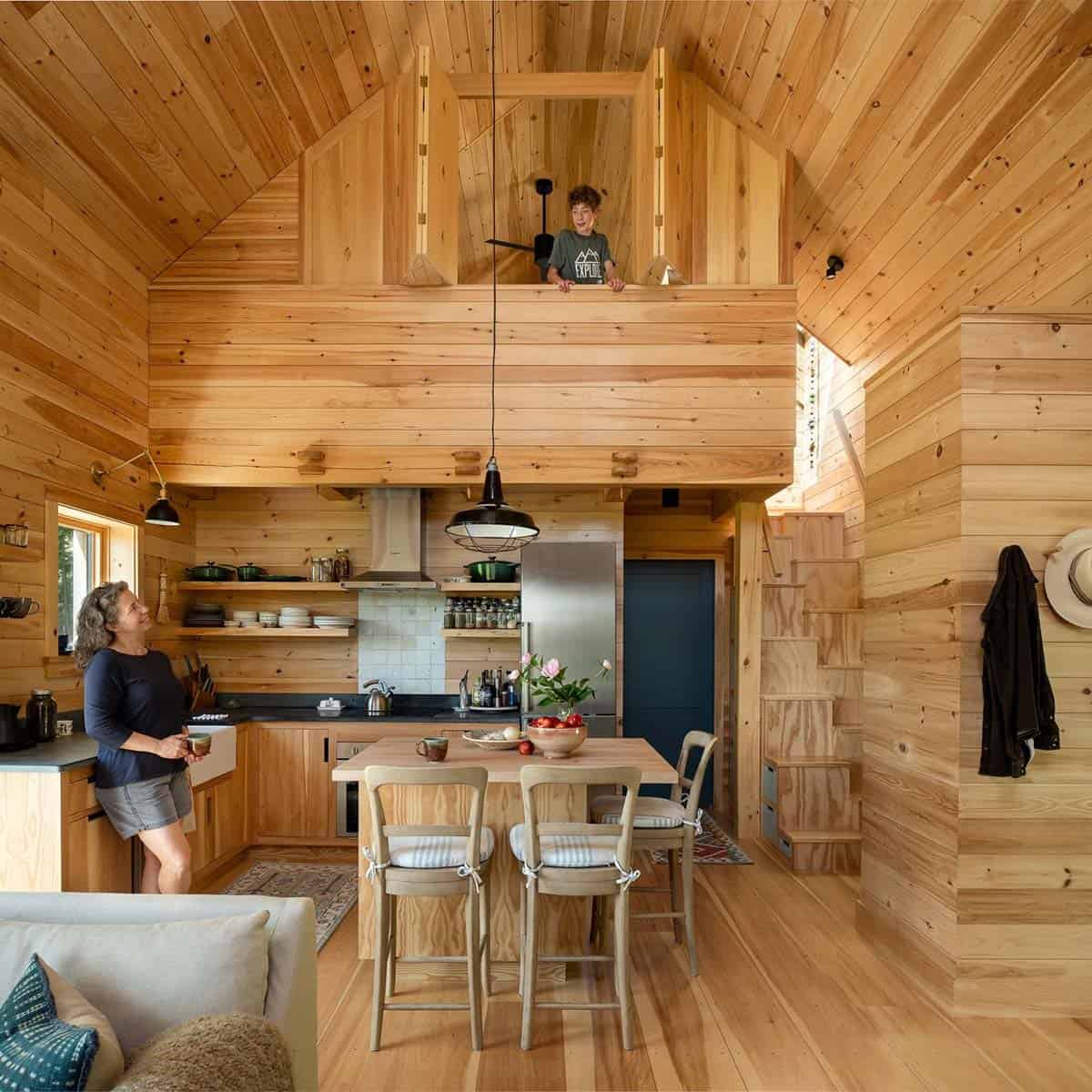 Woman in the kitchen looking up at a child in the loft