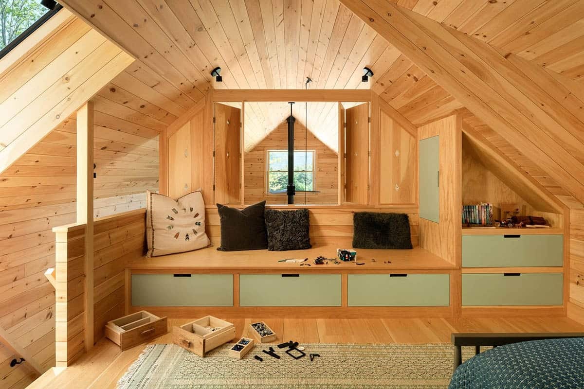 Loft sitting area with built-in bench, sage drawers, and sloped wood ceiling