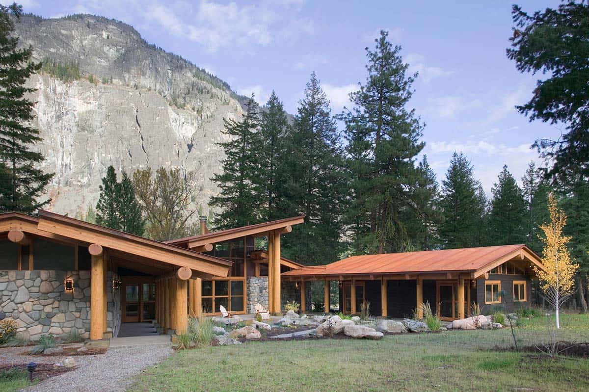 Connected buildings with copper roofing set against dramatic cliff face