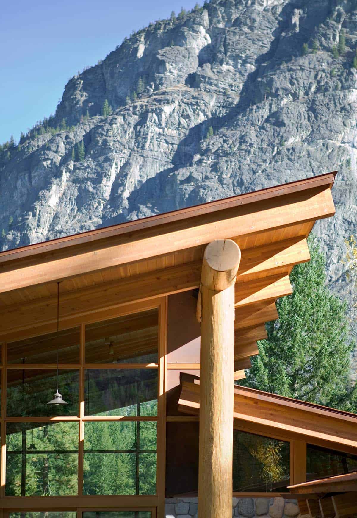 Close-up of log post and eaves against granite cliff backdrop