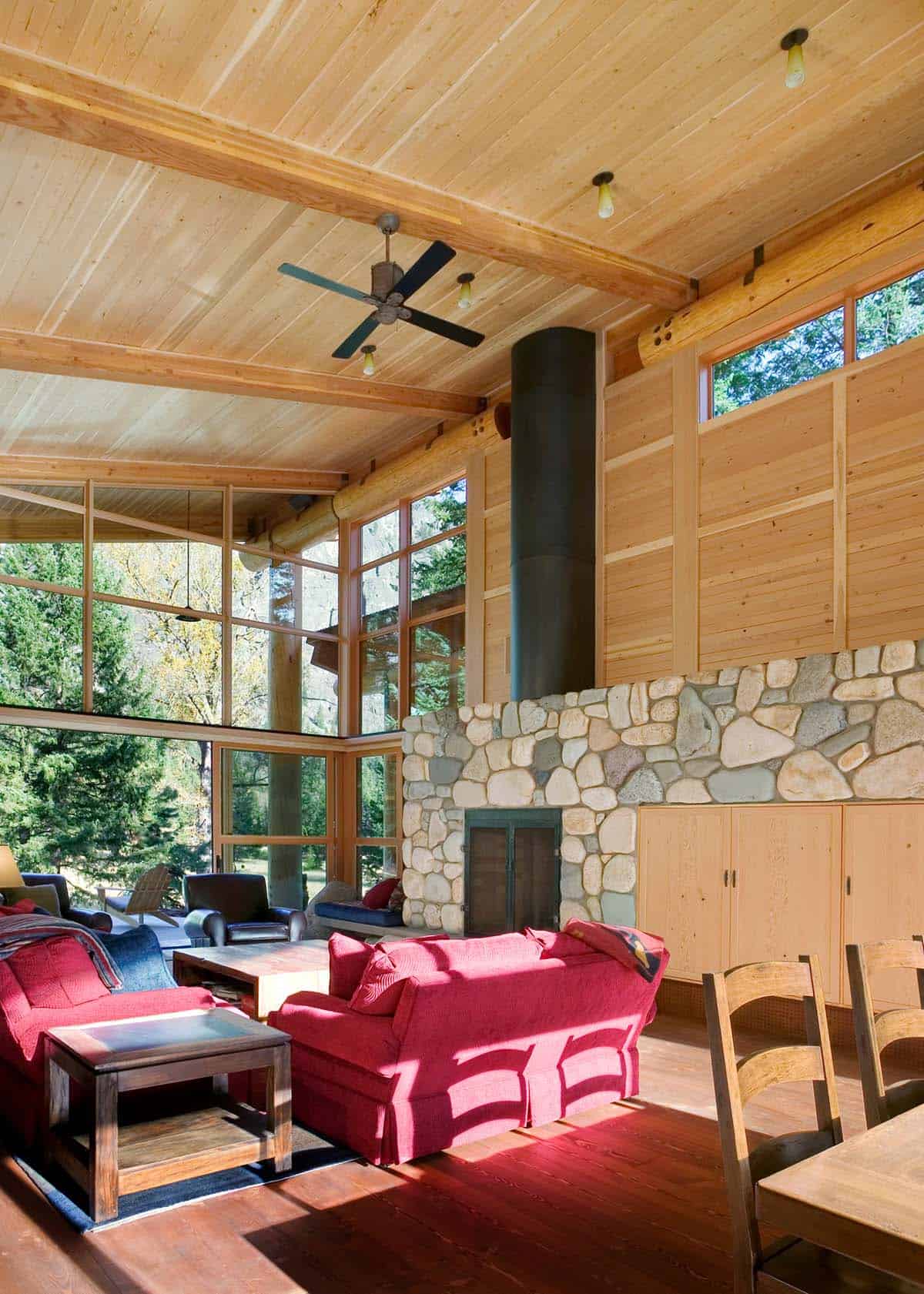Living room with river stone fireplace and vaulted wood ceiling