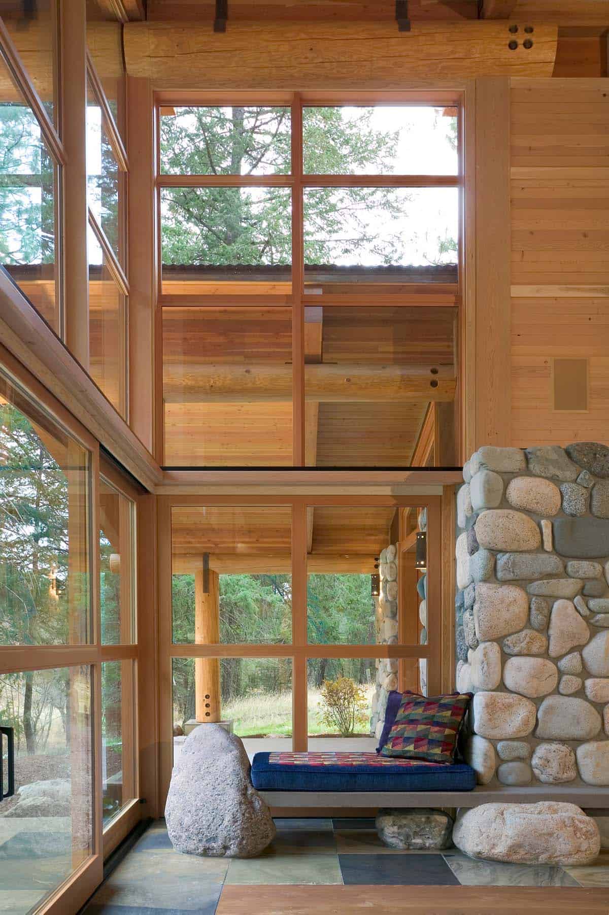 Window nook seating built into stone fireplace with mountain views