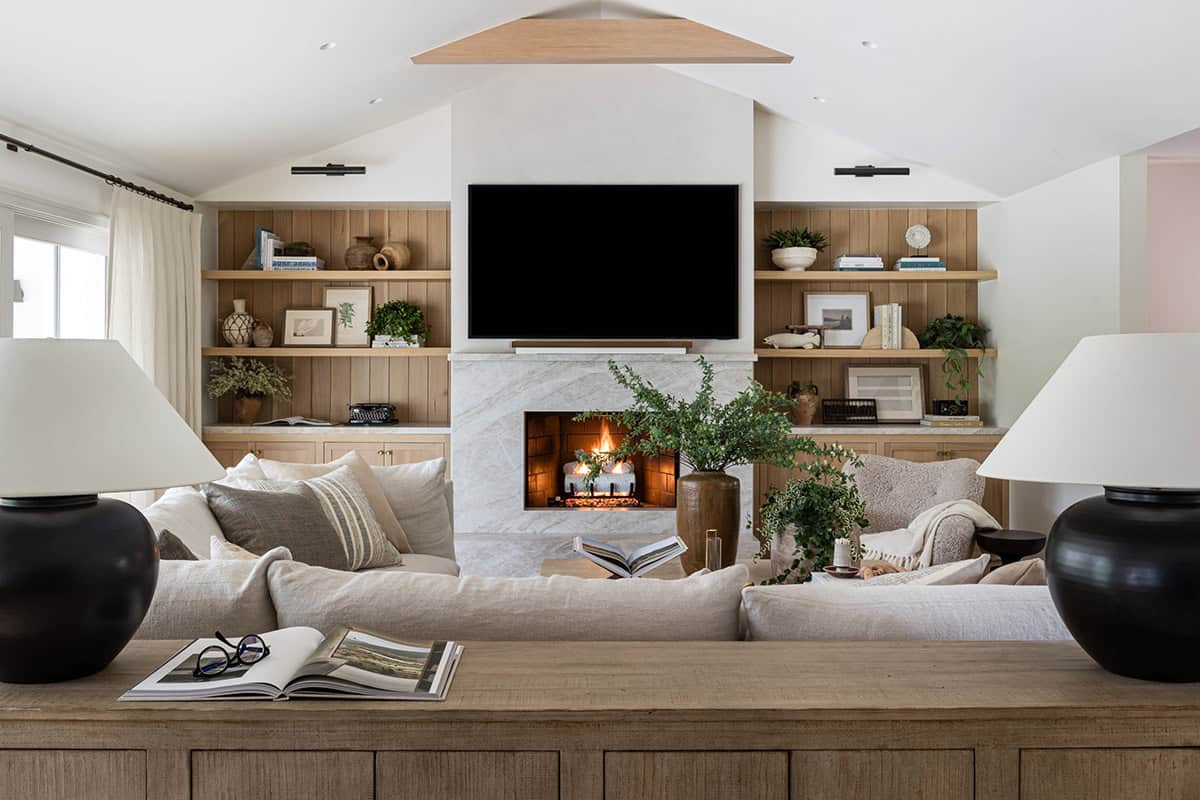 Living room fireplace with marble surround and built-in oak shelving