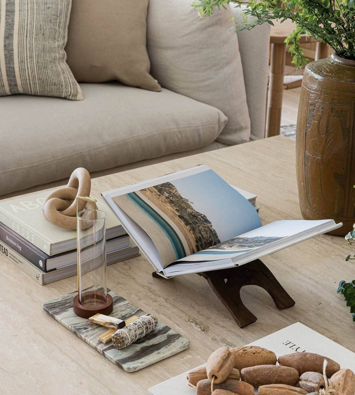 Travertine coffee table styled with coastal books and ceramic decor