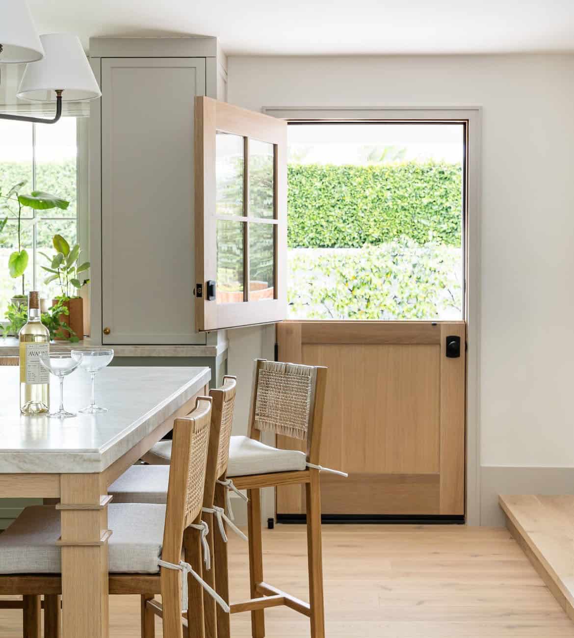 Kitchen Dutch door opening to hedge-lined backyard patio