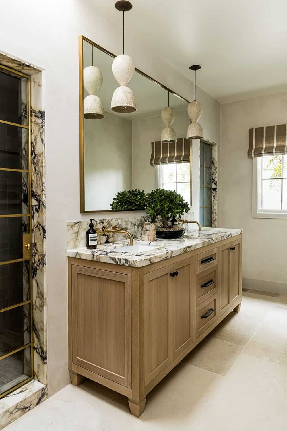 Double vanity with marble top under speckled ceramic pendant lights