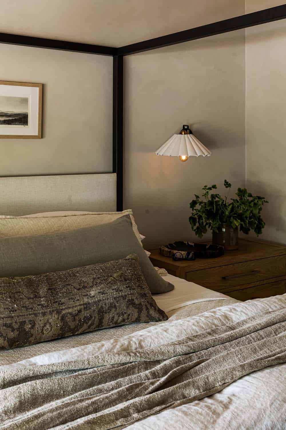Canopy bed detail with pleated sconce and striped throw pillows