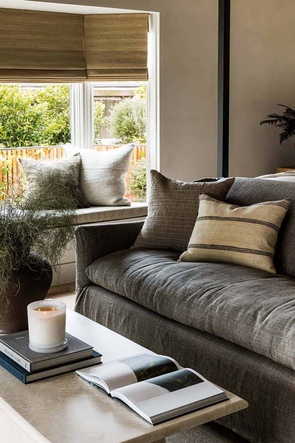 Sectional sofa with striped pillows beside bay window seat