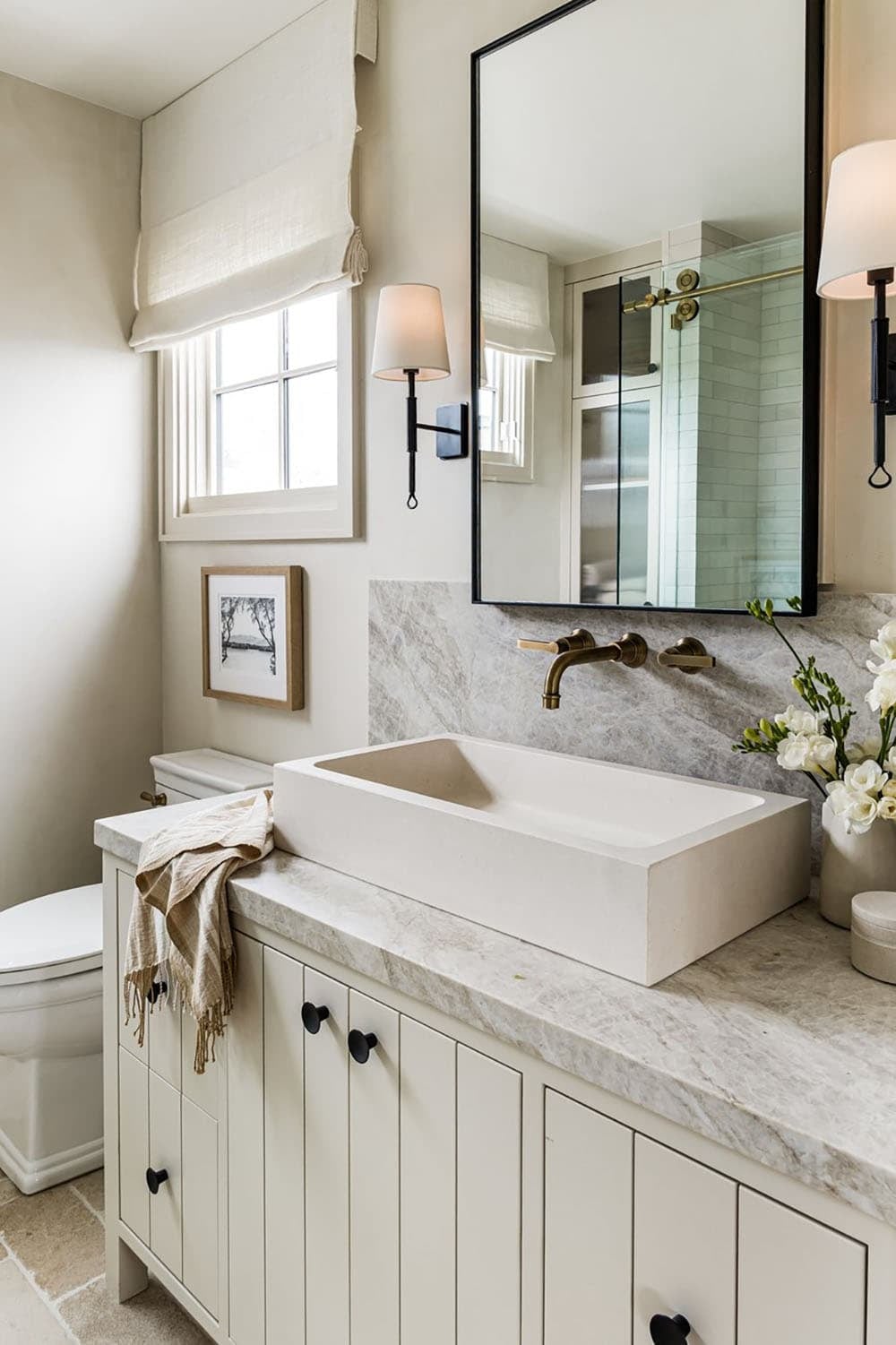 Vessel sink vanity with marble counter and black cabinet knobs