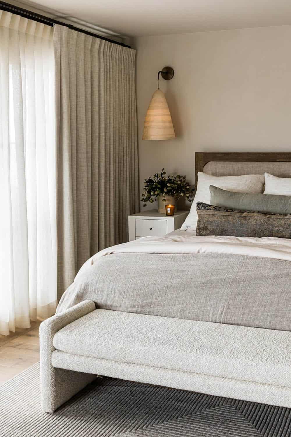 Bed with wood headboard and pleated cone pendant sconce