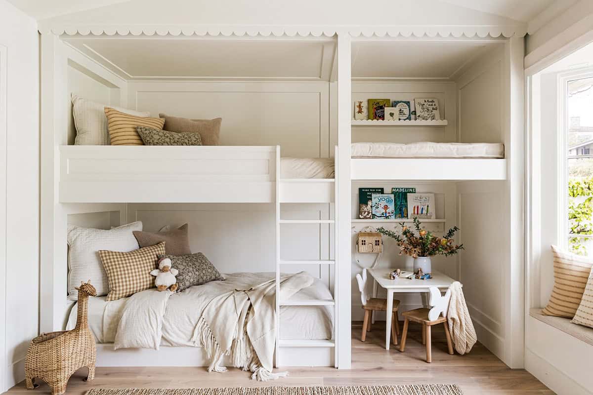 White built-in bunk beds with scalloped trim and play table