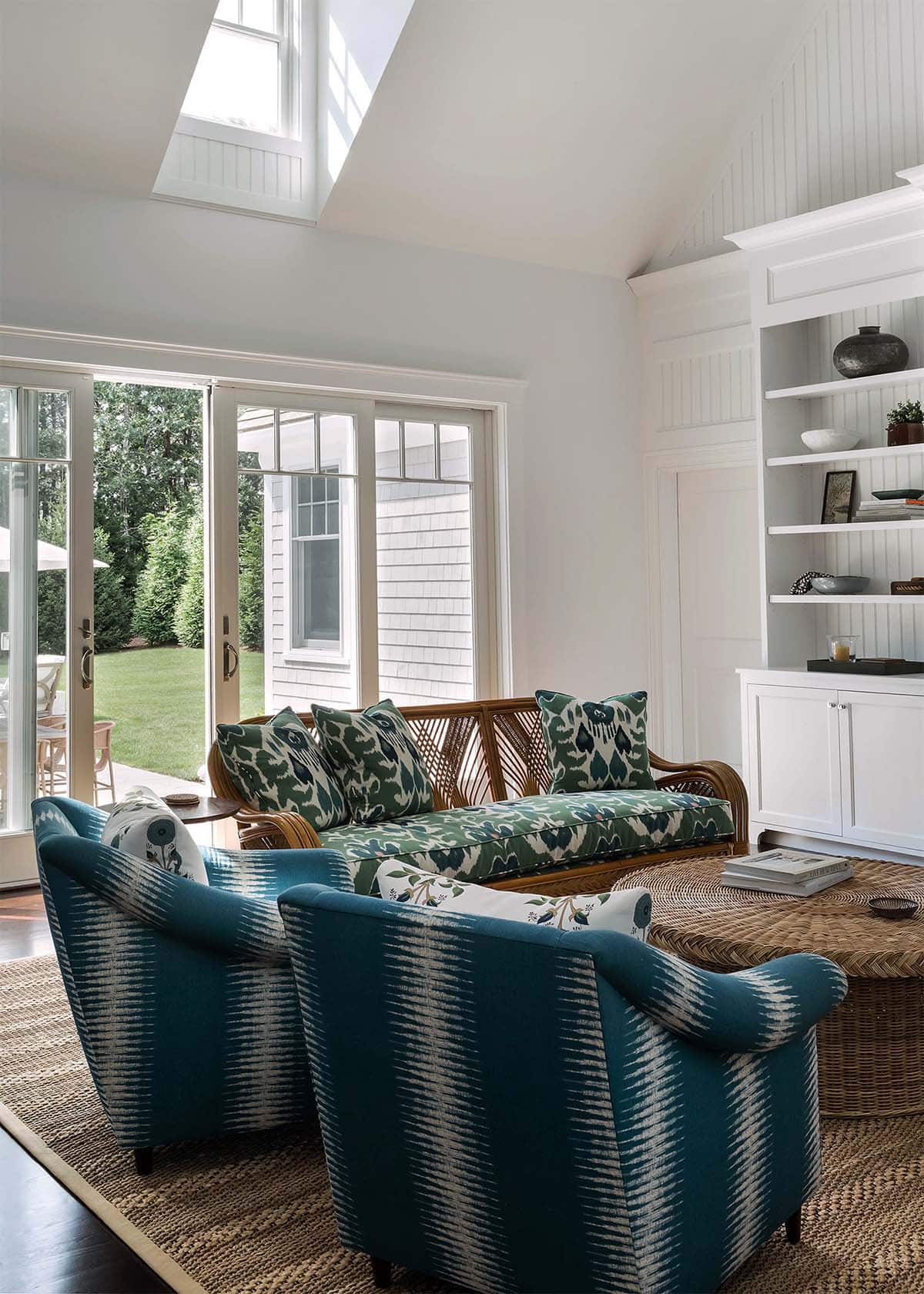 Living room seating below a skylight with rattan sofa