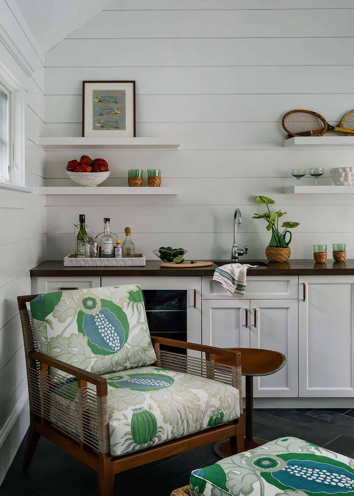 Pool house wet bar with tropical print armchair and shelving