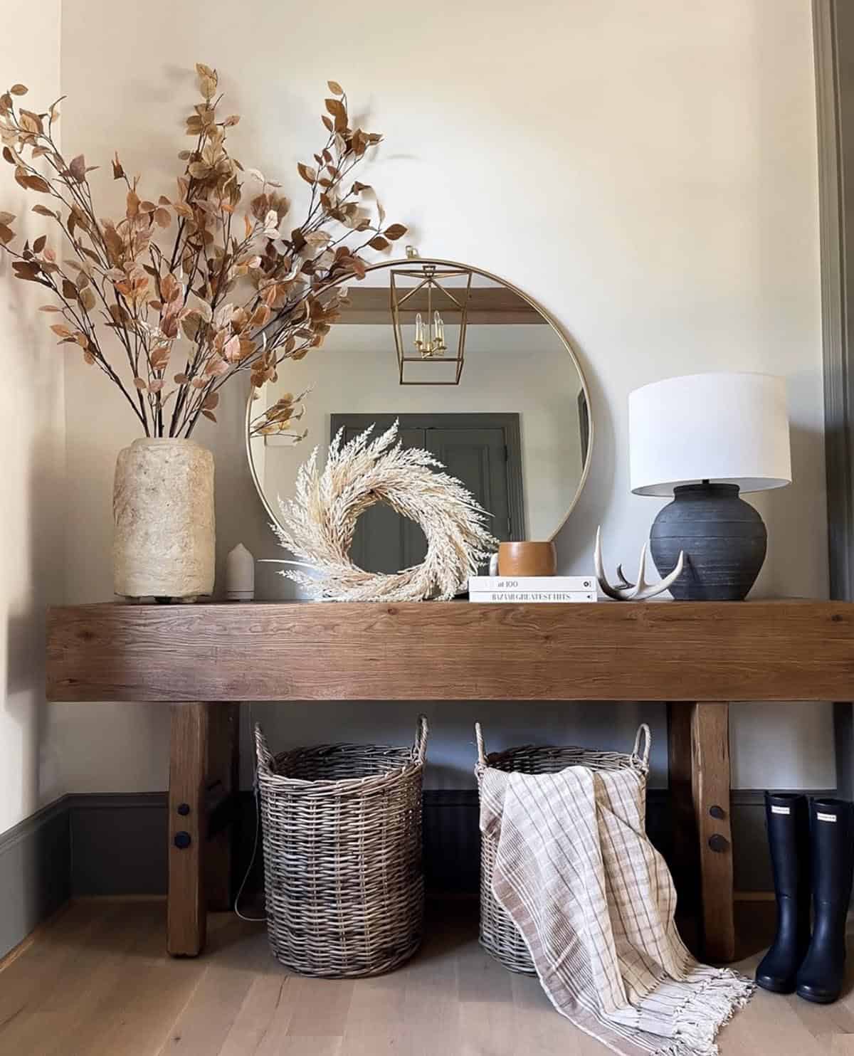 Wood console table with a pampas wreath, mirror and table lamp