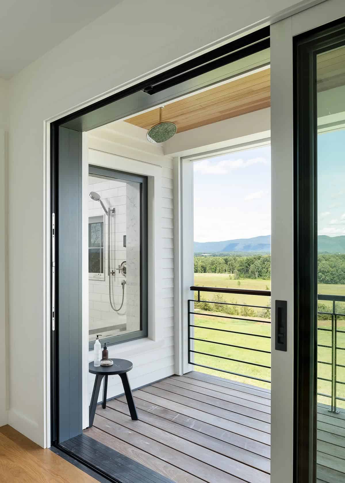 Outdoor second-story shower on a private deck with railing and Green Mountain views