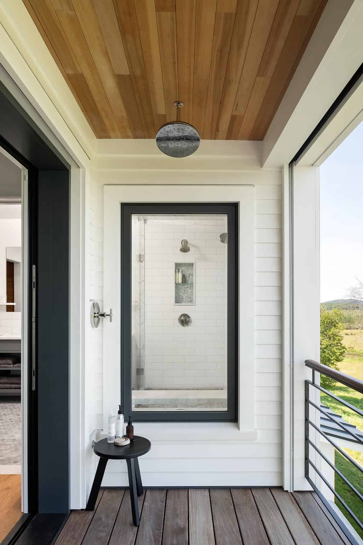 Second-story outdoor shower with rainfall showerhead under a cedar ceiling on a private deck