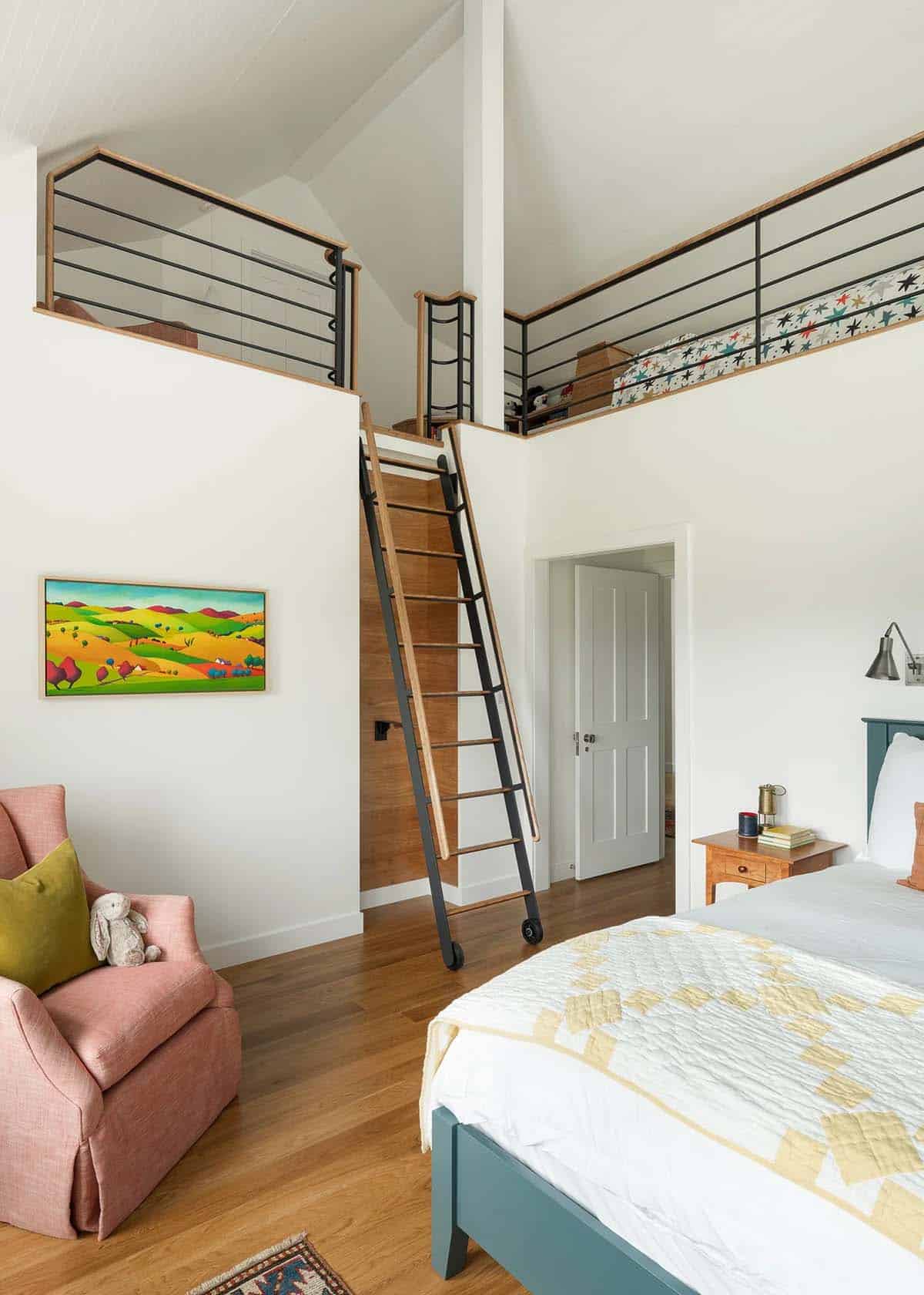 Child's bedroom with sleeping loft, rolling ladder, and steel railing beneath a vaulted ceiling