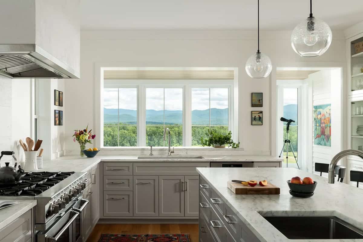 Kitchen sink window overlooking the Green Mountains with marble counters and gray cabinetry