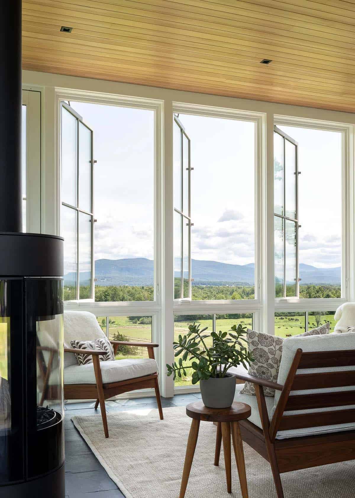 Sunroom casement windows open to Green Mountain views beside a modern stove