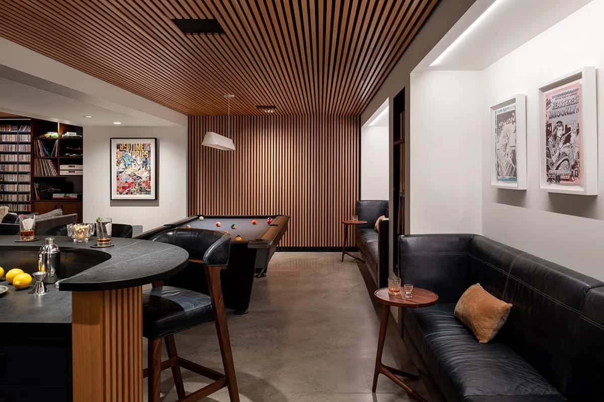 Game room with slatted wood ceiling, pool table, curved bar, and black leather banquette