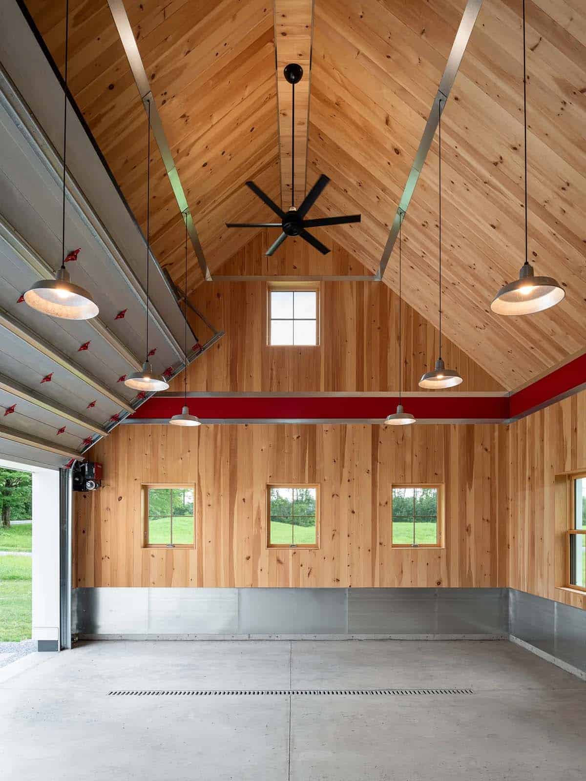 Garage interior with vaulted pine ceiling, red accent band, barn pendant lights, and ceiling fan