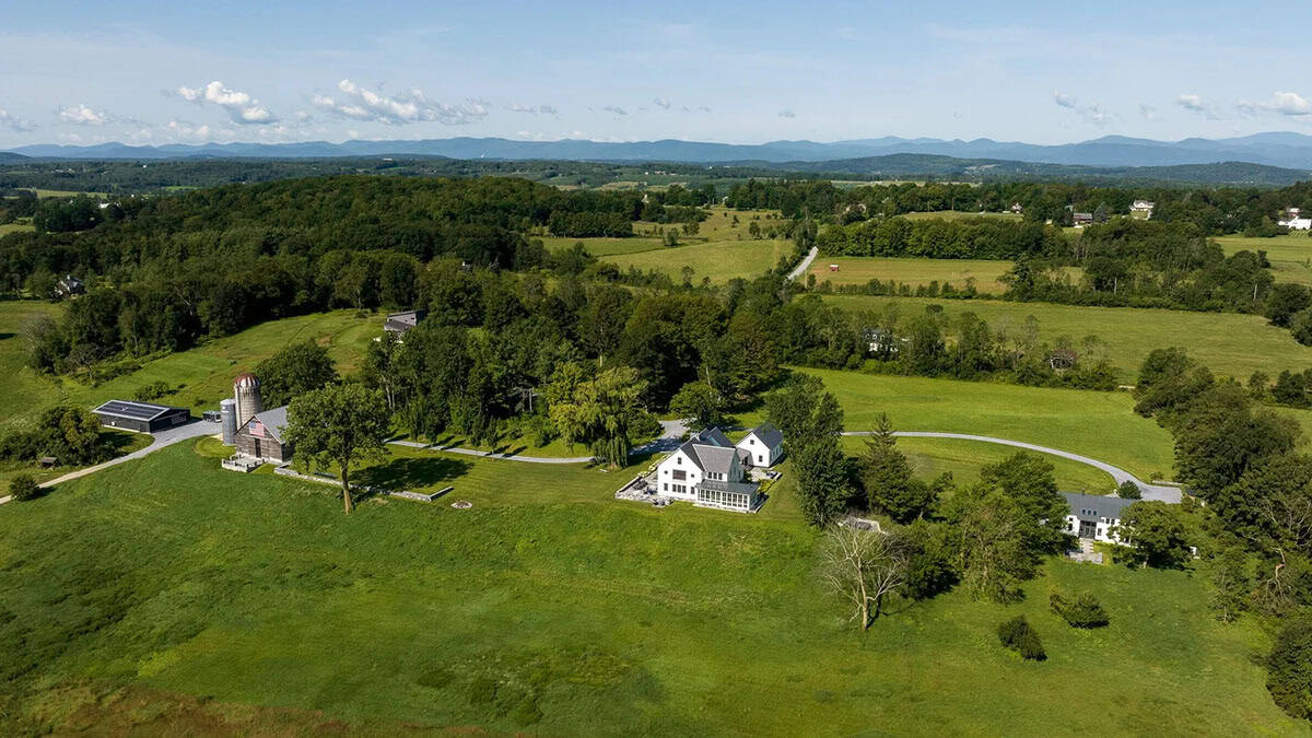 Aerial view of the Cornwall, Vermont farmhouse with barn, silo, and Green Mountains beyond