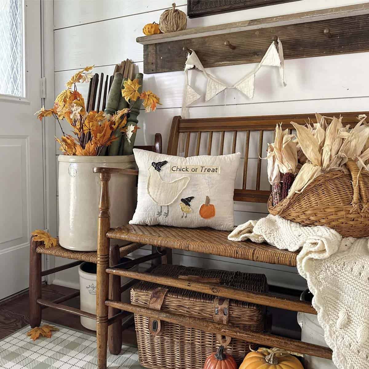 Vintage cane bench with a handmade fall pillow and corn husk basket