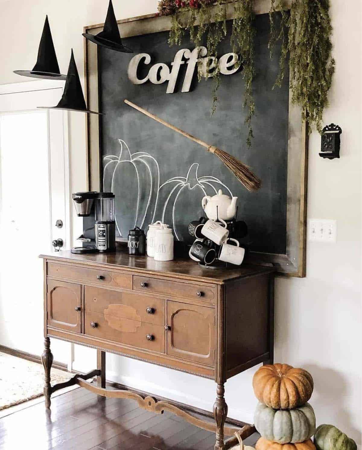 Coffee station with chalkboard pumpkins, floating witch hats, and floating broom above buffet