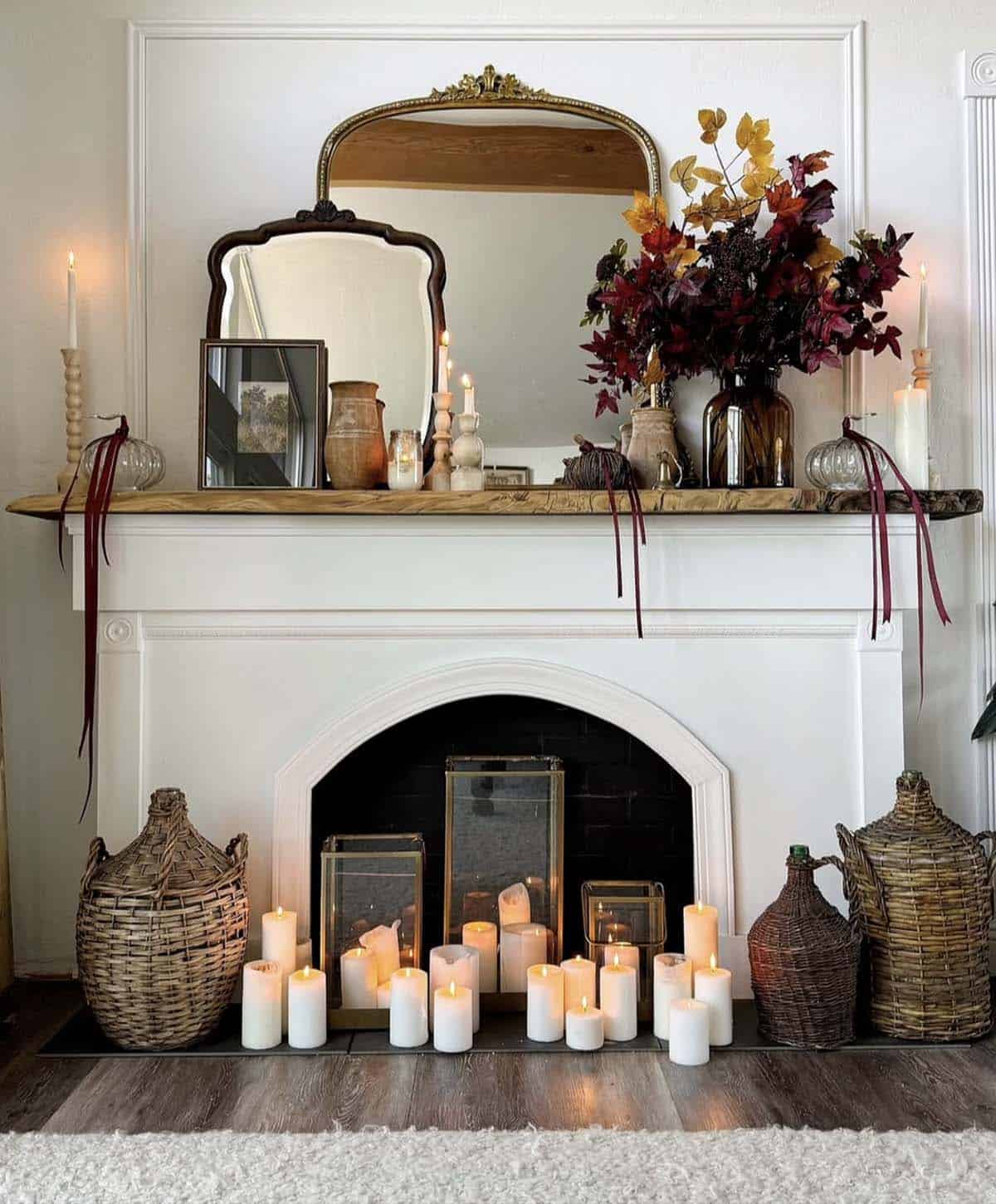 Fireplace opening filled with clustered pillar candles and lanterns