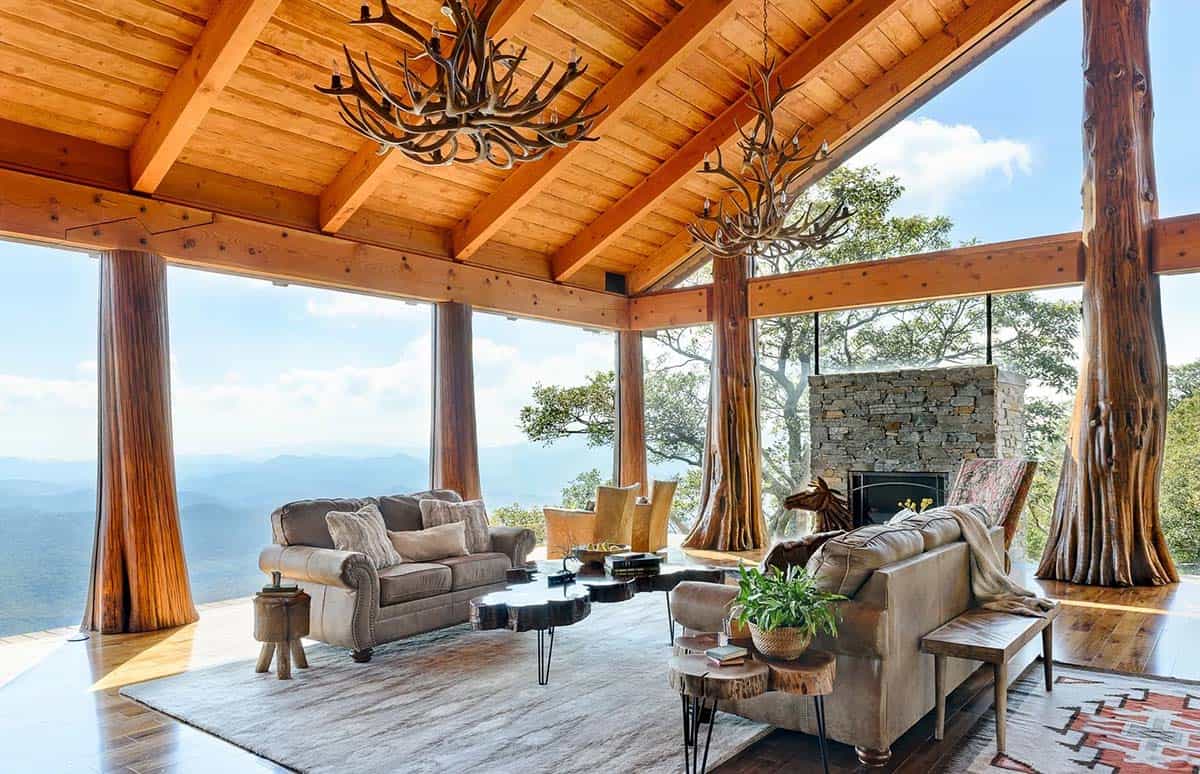 Open air living room with tree trunk columns and antler chandeliers