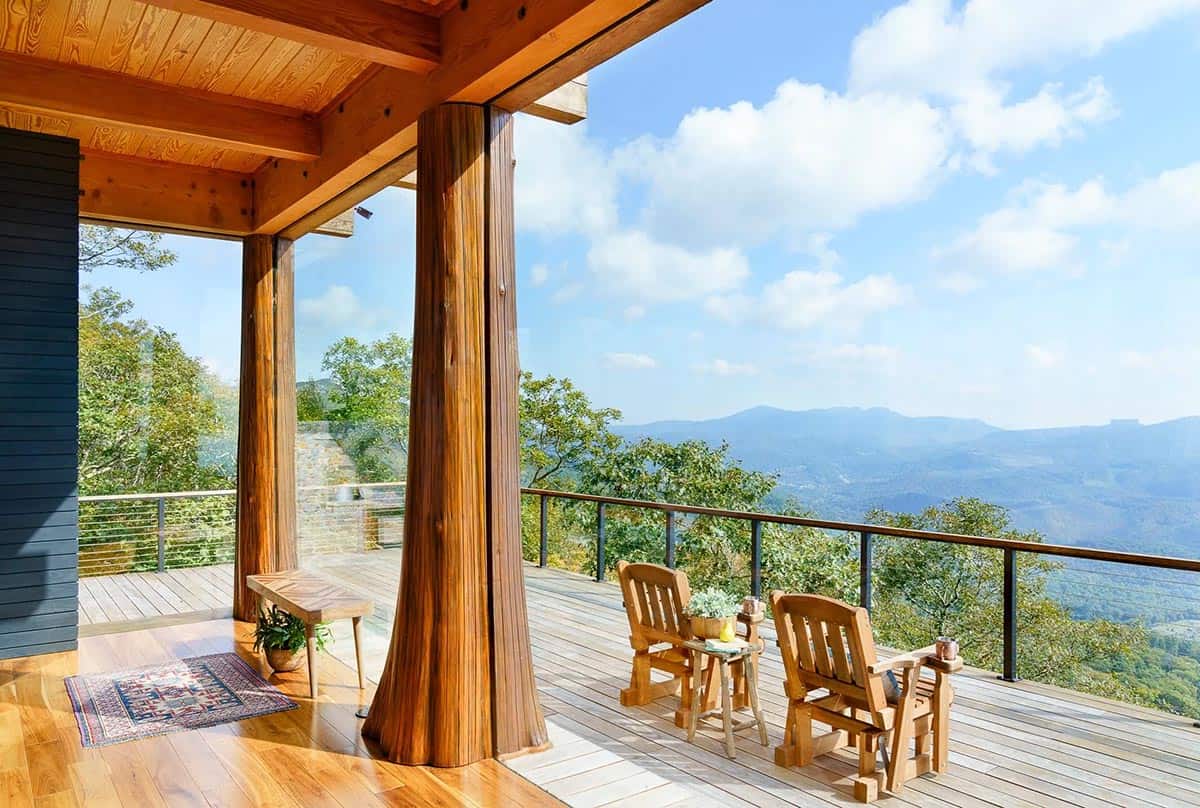 Wooden rocking chairs on a deck with mountain valley views